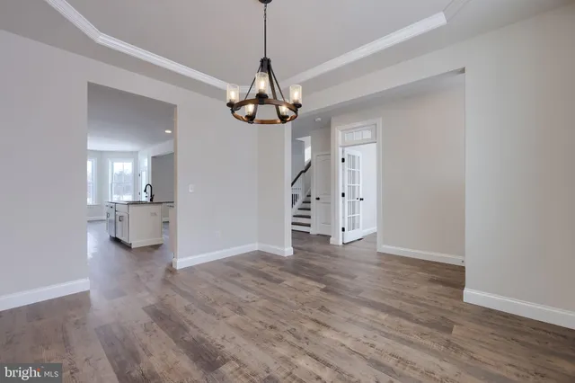 a view of empty room with wooden floor and window