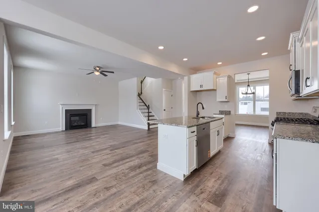 a large kitchen with stainless steel appliances granite countertop a stove and a sink