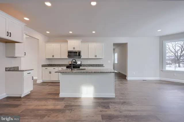 a kitchen with granite countertop white cabinets and appliances