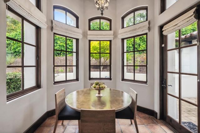 a dining room with furniture a rug a potted plant and a potted plant