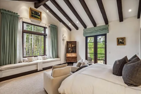 a bedroom with furniture and large windows