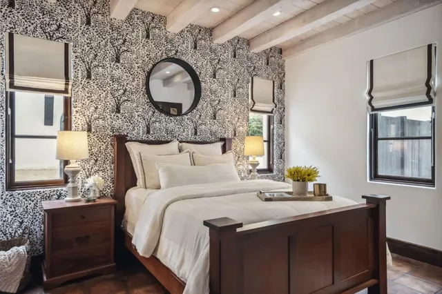 a bedroom with a bed and dresser with wooden floor