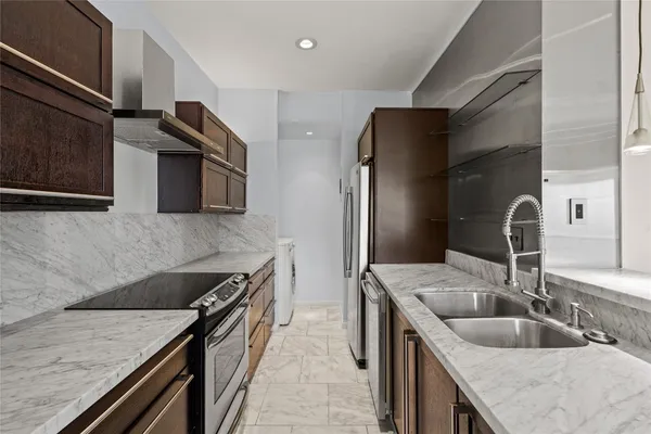 a kitchen with stainless steel appliances a sink and a refrigerator