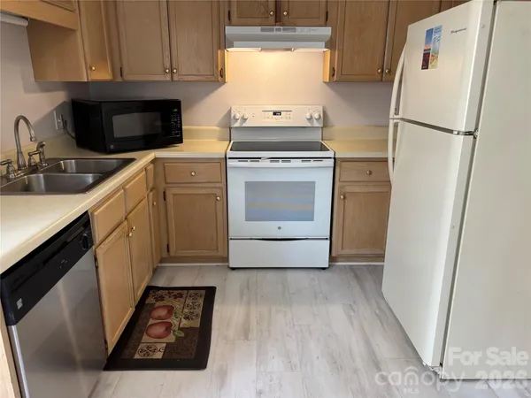 a kitchen with a stove a refrigerator and a sink