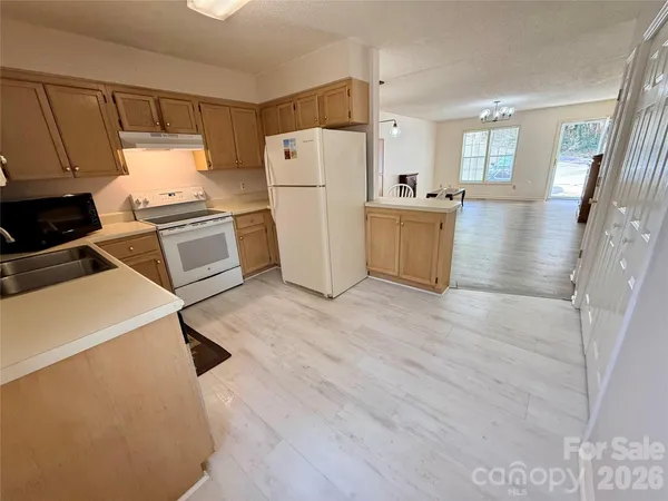 a kitchen with a refrigerator a stove and wooden floor