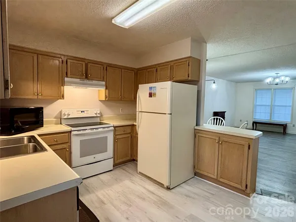 a kitchen with a refrigerator sink and white cabinets