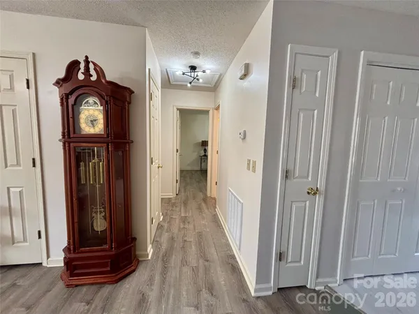 a view of a hallway with wooden floor and stairs
