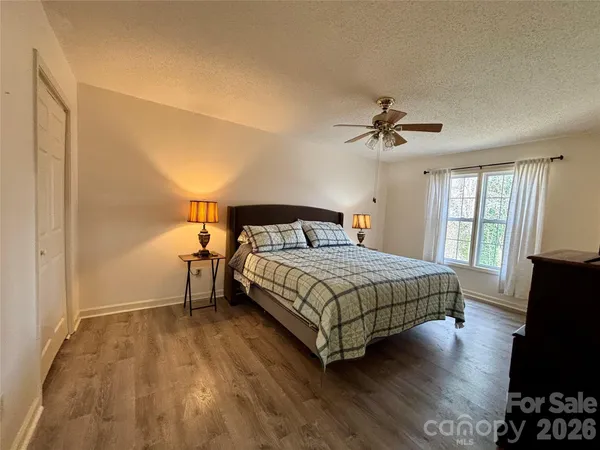 a bedroom with a bed and a flat tv screen on dresser