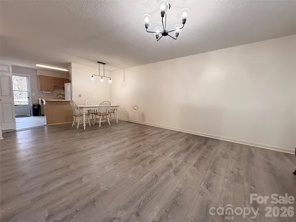 a view of a room with furniture wooden floor and chandelier