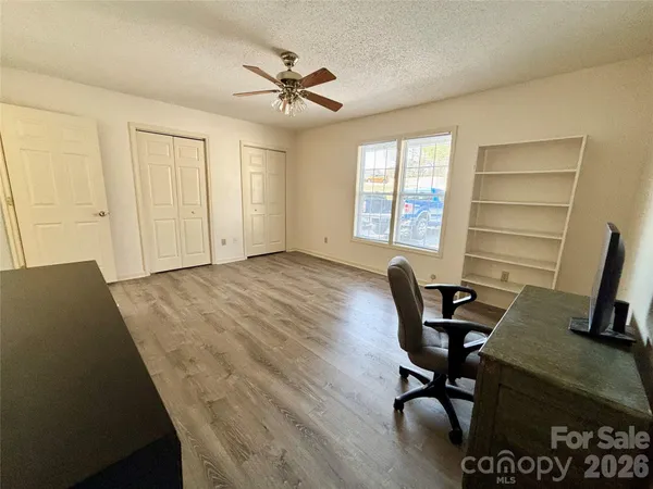 a view of a workspace with furniture and a window