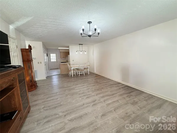 a view of a dining room with furniture a chandelier and wooden floor