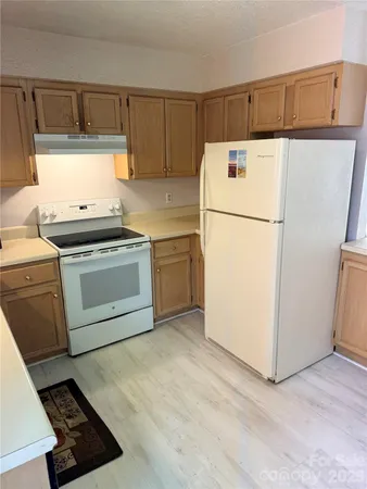a white refrigerator freezer and a stove sitting inside of a kitchen