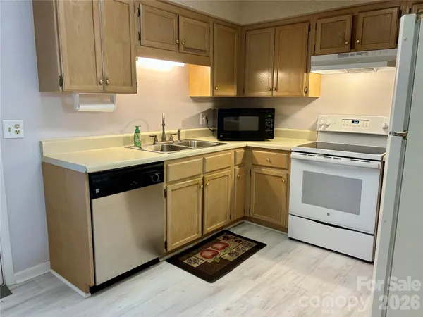 a kitchen with a stove sink and cabinets