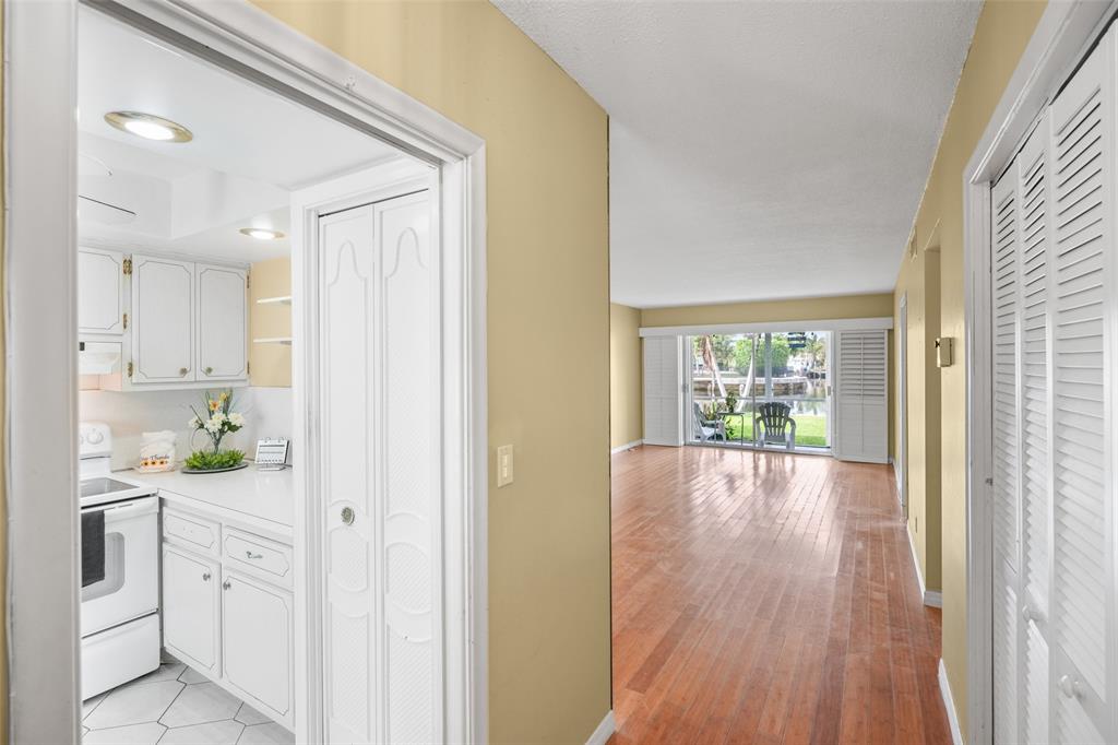 1100 Pine Drive, Unit 107 Pompano Beach, FL 33060 - Photo 3 of 40 a view of a hallway to dining room and wooden floor