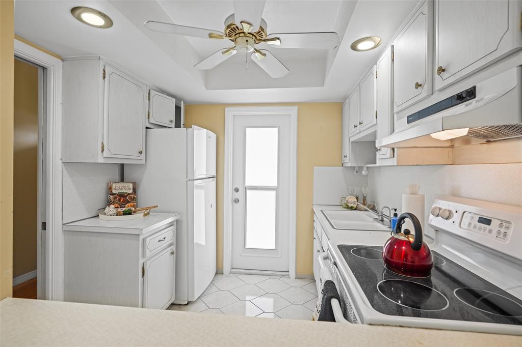 1100 Pine Drive, Unit 107 Pompano Beach, FL 33060 - Photo 7 of 40 a utility room with stainless steel appliances kitchen island granite countertop a refrigerator and a stove