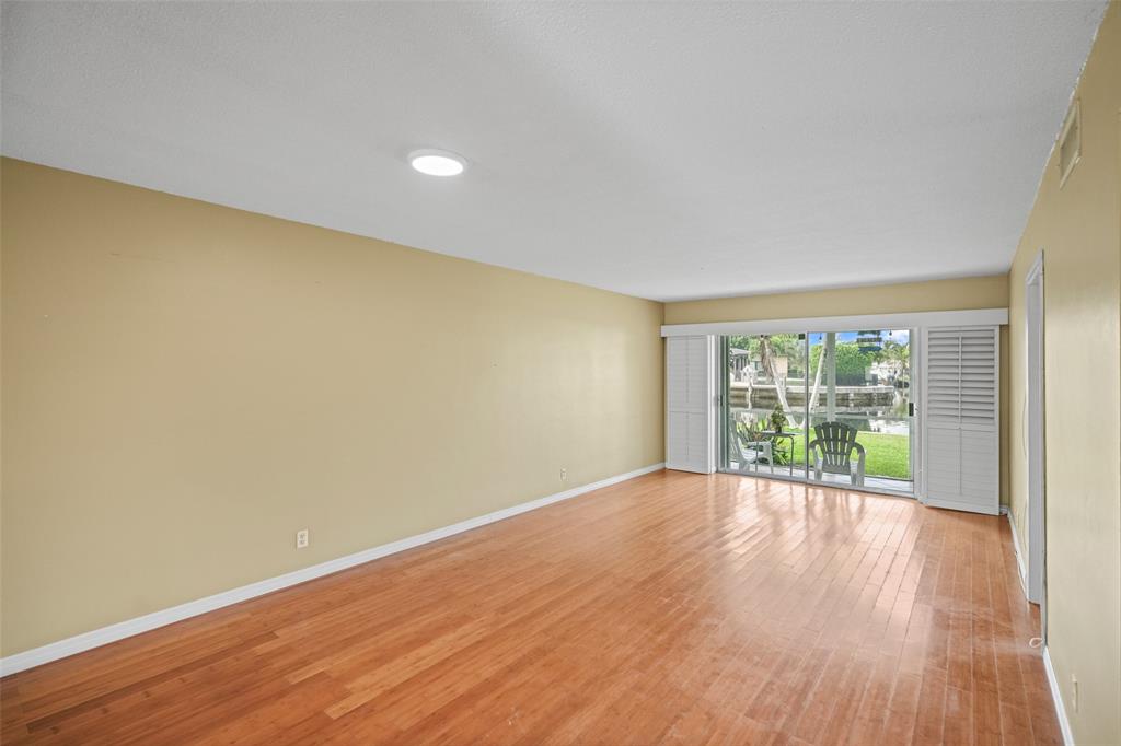 1100 Pine Drive, Unit 107 Pompano Beach, FL 33060 - Photo 8 of 40 a view of an empty room with wooden floor and a window