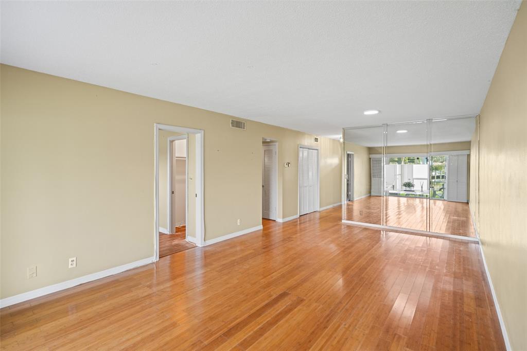 1100 Pine Drive, Unit 107 Pompano Beach, FL 33060 - Photo 9 of 40 a view of empty room with wooden floor