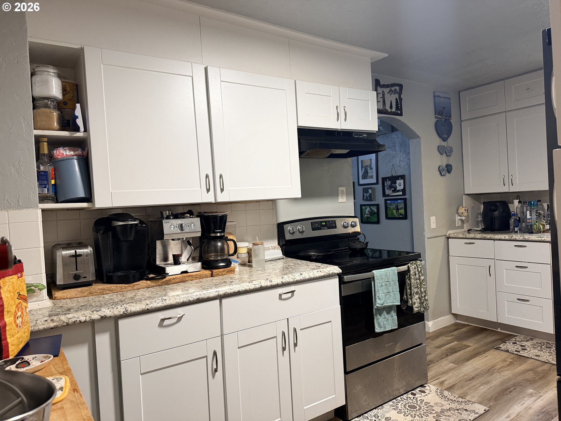 677 Southeast Moffitt Road Waldport, OR 97394 - Photo 17 of 36 a kitchen with granite countertop white cabinets and black stainless steel appliances