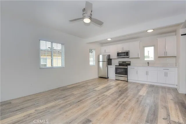 a view of kitchen with wooden floor electronic appliances and window