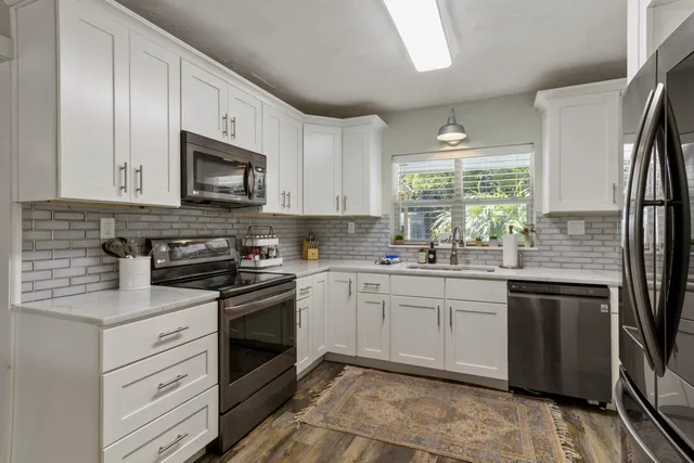 a kitchen with a refrigerator sink and cabinets