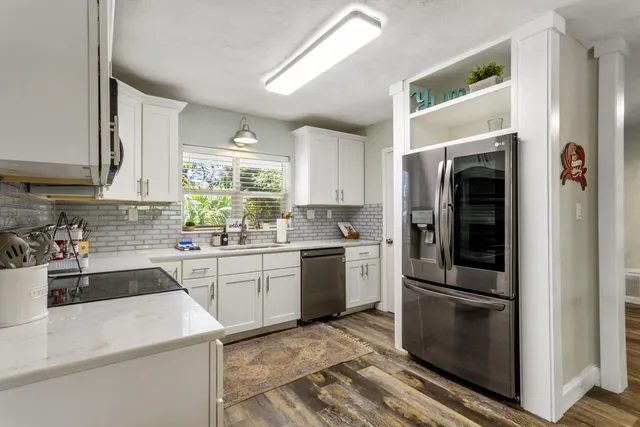 a kitchen with a white cabinets and chairs