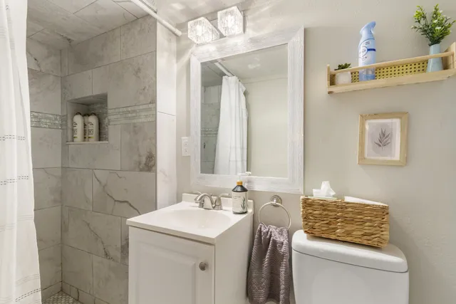 a living room with furniture a kitchen view and a refrigerator