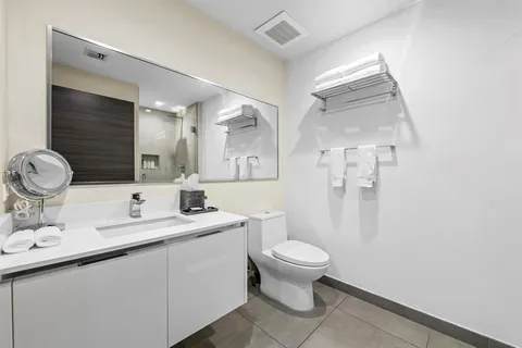 a bathroom with a toilet sink and mirror