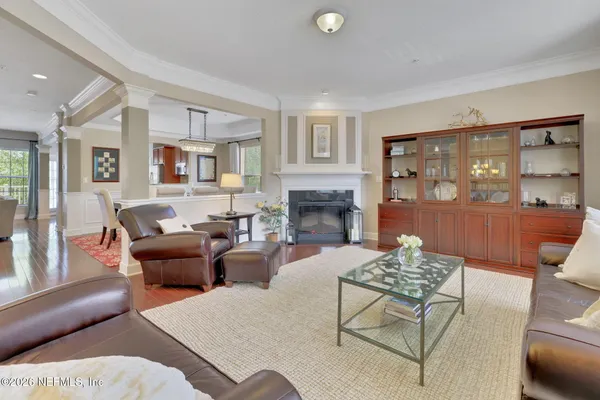 a dining room with wooden floor a chandelier a wooden table and chairs