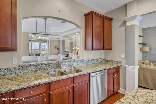 a kitchen with kitchen island granite countertop wooden cabinets a sink and dishwasher