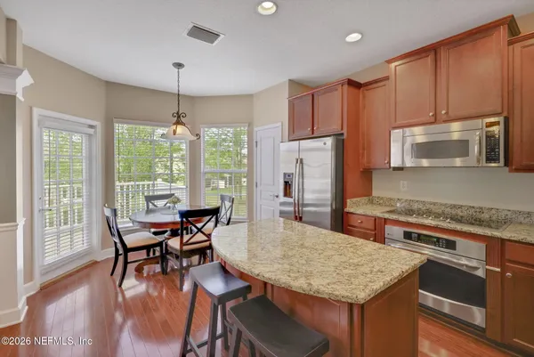 a kitchen with stainless steel appliances granite countertop a stove a sink and a microwave