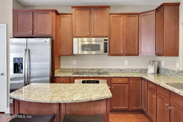 a kitchen with stainless steel appliances granite countertop a sink stove and refrigerator