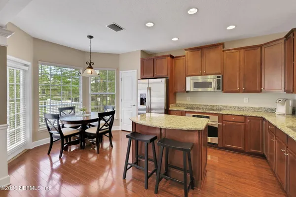 a kitchen with granite countertop kitchen island a sink stove and wooden cabinets