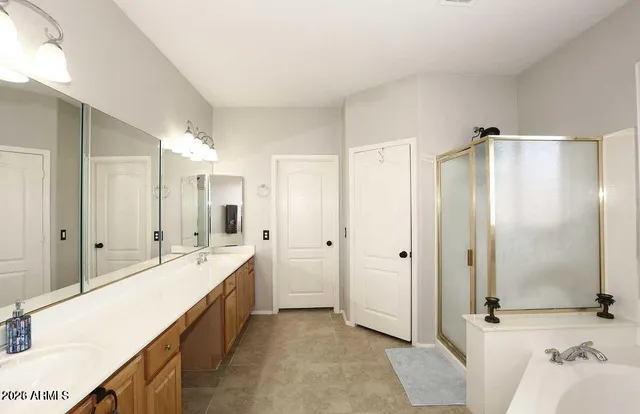 a spacious bathroom with a double vanity sink mirror and shower