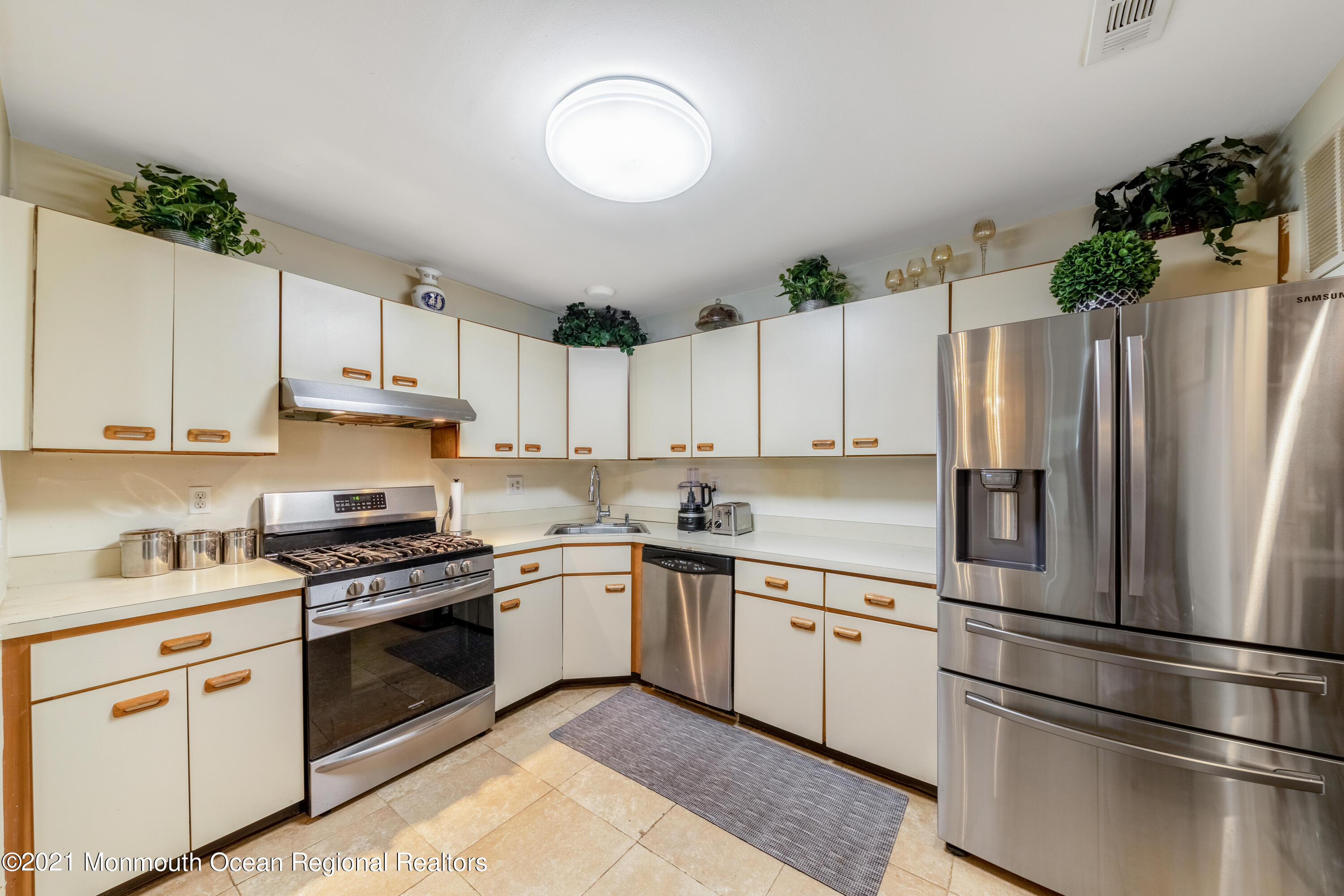 a kitchen with white cabinets stainless steel appliances and a sink