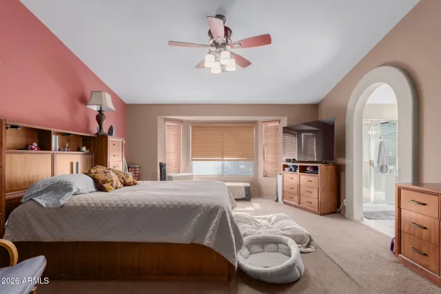 a bedroom with a bed a window and a chandelier