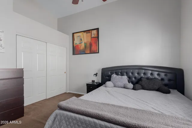 a bedroom with a bed and a painting on the wall