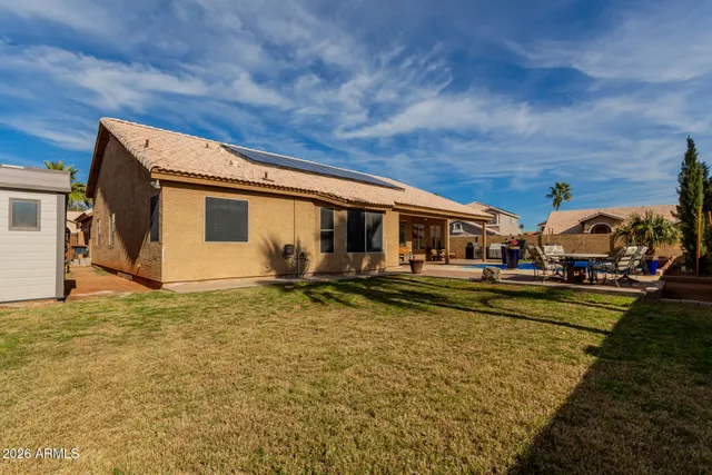 a view of a house with pool and chairs