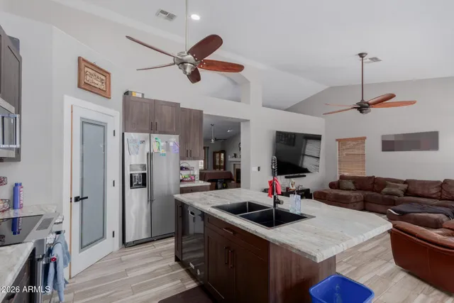 a kitchen with stainless steel appliances granite countertop a sink a stove and a refrigerator