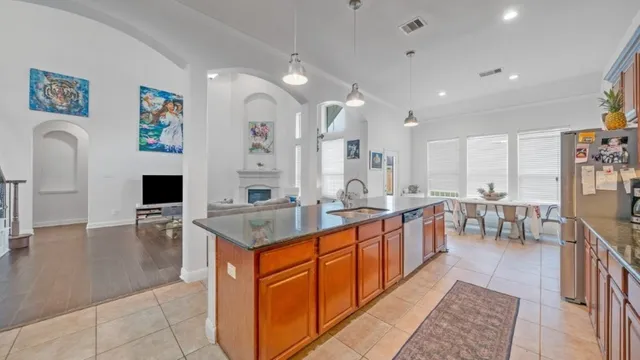 a large kitchen with kitchen island a sink table and chairs