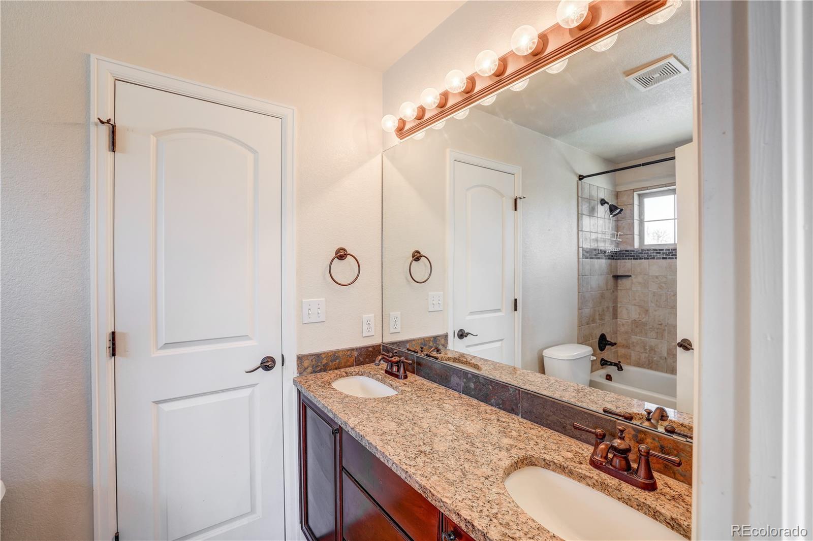 4530 Quitman Street Denver, CO 80212 - Photo 27 of 40 a bathroom with a granite countertop sink and a mirror