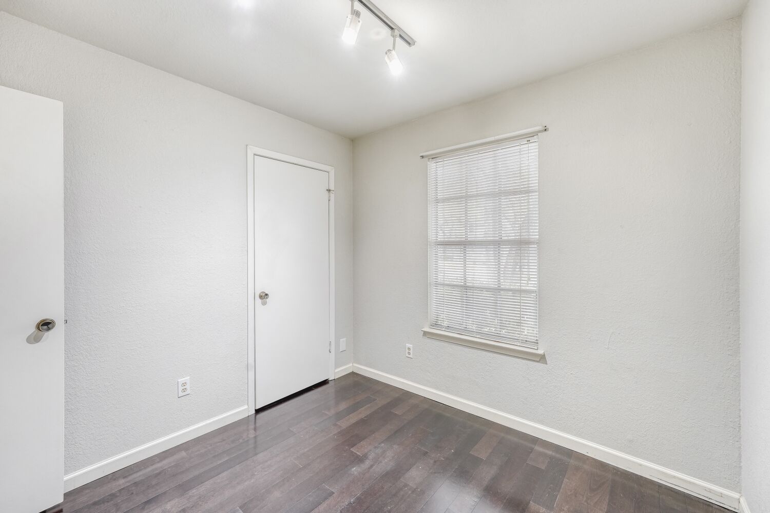 9100 Wagtail Drive Austin, TX 78748 - Photo 14 of 23 Bedroom featuring dark wood-style flooring, a textured wall, and rail lighting