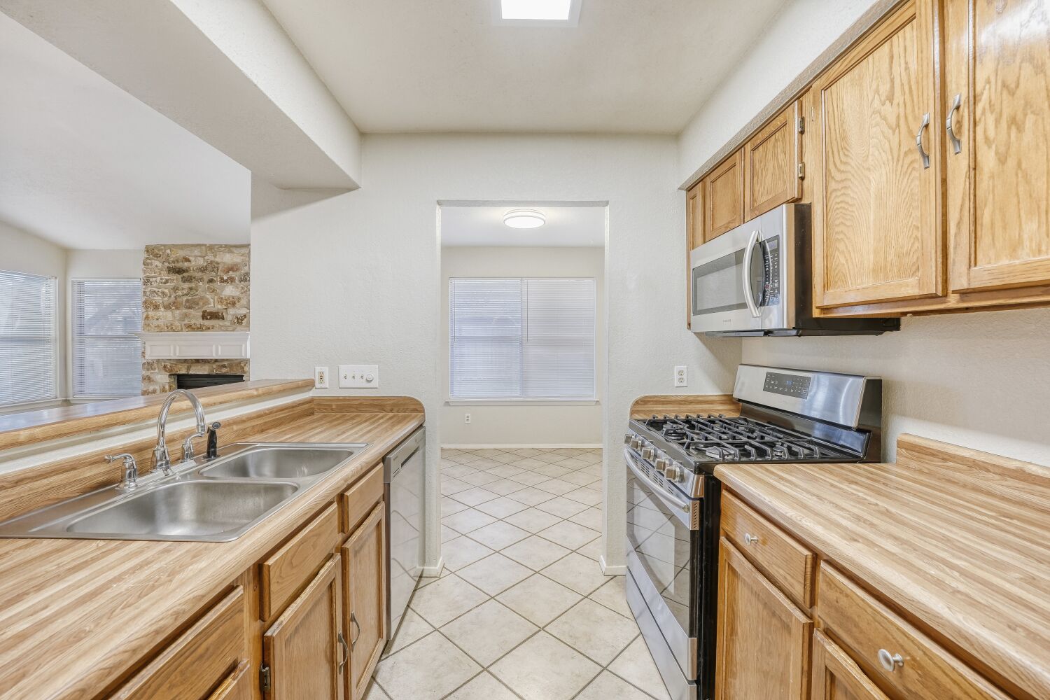9100 Wagtail Drive Austin, TX 78748 - Photo 5 of 23 Kitchen featuring stainless steel range with gas cooktop, and dishwasher. It opens to both dining area and living room.