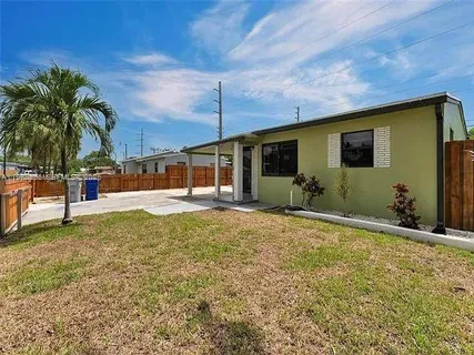 a view of a house with backyard and sitting area