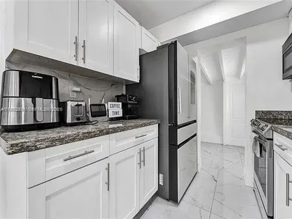 a kitchen with stainless steel appliances granite countertop a sink and a stove