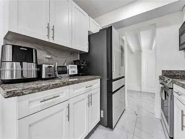 a kitchen with stainless steel appliances granite countertop a sink and a stove