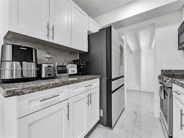2730 Northeast 16th Avenue Pompano Beach, FL 33064 - Photo 13 of 16 a kitchen with stainless steel appliances granite countertop a refrigerator and a stove