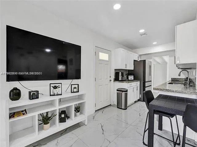 2730 Northeast 16th Avenue Pompano Beach, FL 33064 - Photo 6 of 16 a living room with stainless steel appliances furniture and a flat screen tv