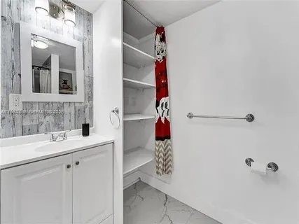 a living room with stainless steel appliances a flat screen tv and view of kitchen