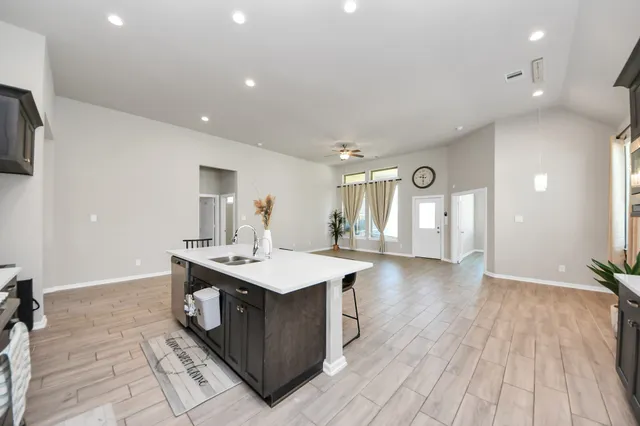 a kitchen with stainless steel appliances a sink a stove top oven a counter space and cabinets