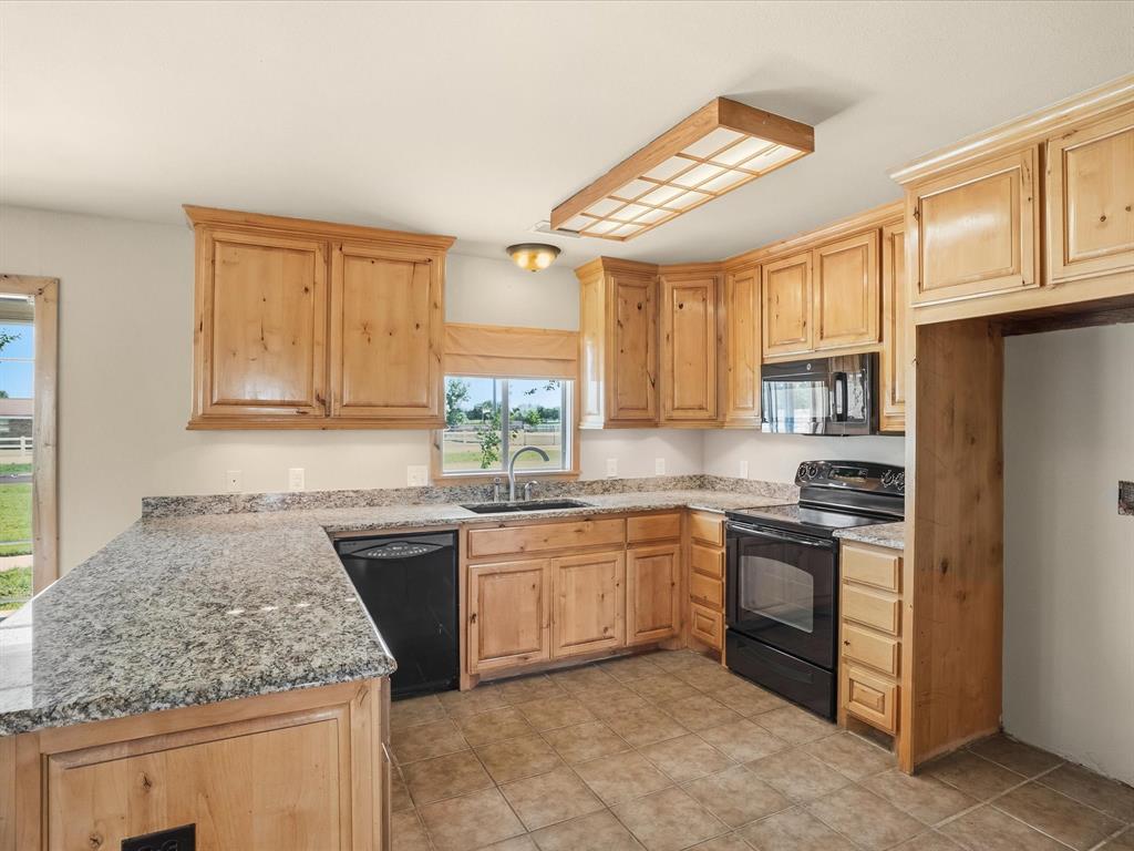 6568 Michael Road Sanger, TX 76266 - Photo 8 of 33 a kitchen with stainless steel appliances granite countertop a stove sink and cabinets
